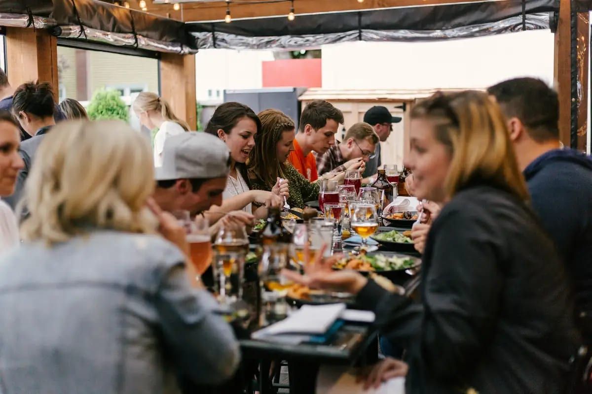 Friends talking and eating together at a long table
